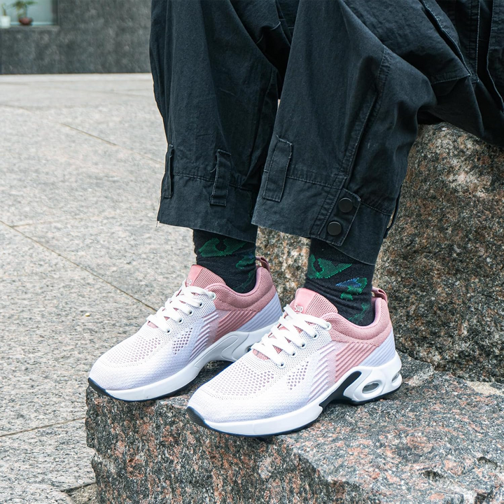 Light pink lightweight walking sneakers with white laces worn with dark denim pants