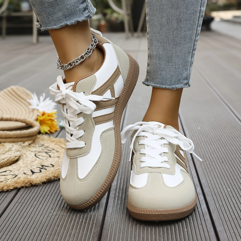 Low top lace-up sneakers with white laces, tan-and-white panels, gum sole, chain ankle