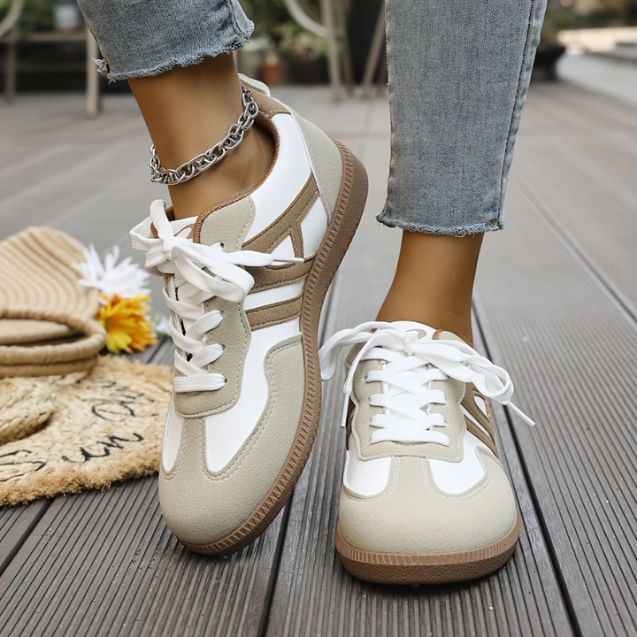Low top lace-up sneakers with white laces, tan-and-white panels, gum sole, chain ankle
