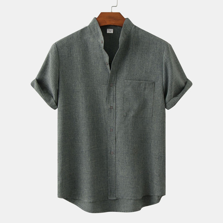 Dark green solid cotton button-up shirt with short sleeves and chest pocket.