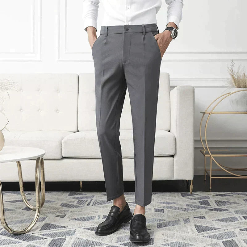 Grey stretch pants on model; straight leg with belt loops and button front