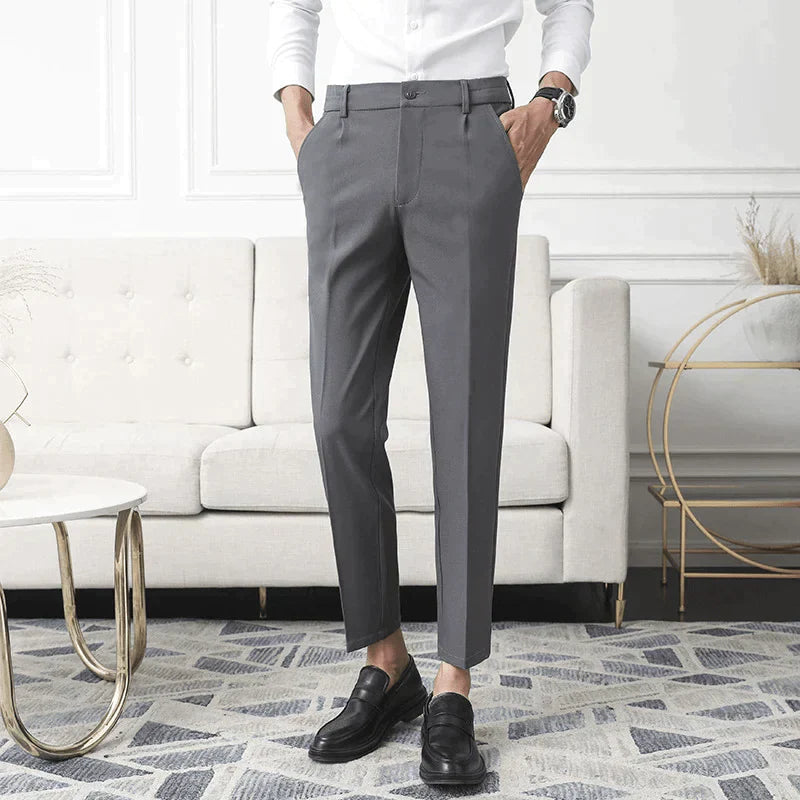 Gray stretch pants worn straight-leg with cuffed ankle hem