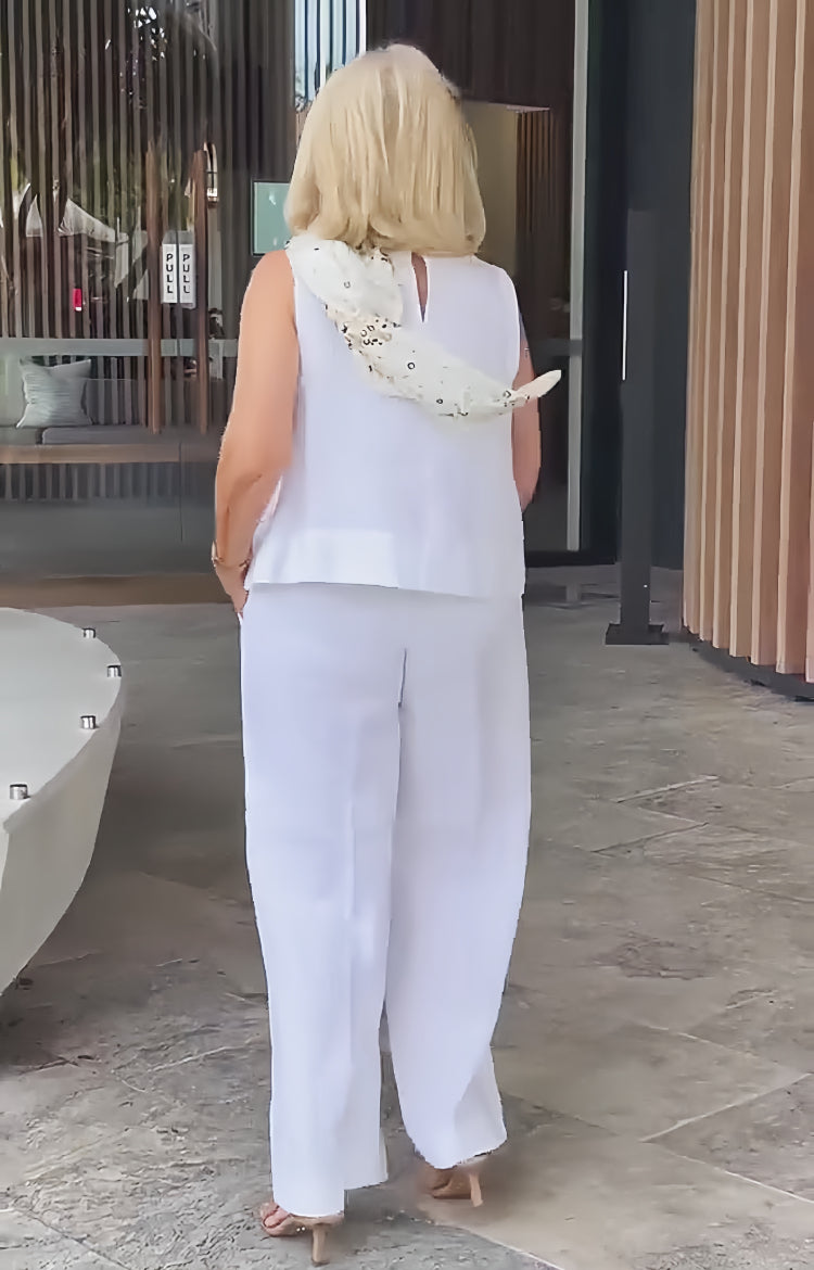 Back view: white sleeveless layered top and matching wide-leg pants