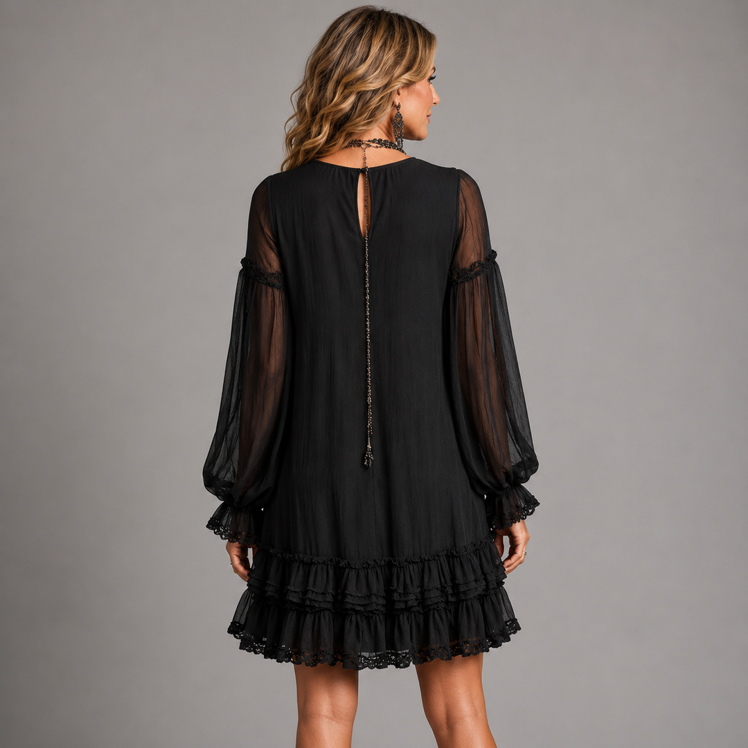 Black mini dress back view with sheer sleeves and long center tie, tiered ruffle hem