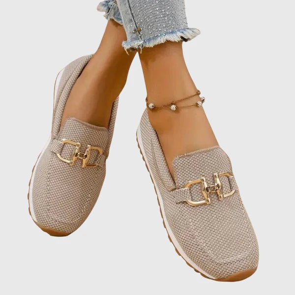 Beige women's slip-on loafers with gold buckle accent and cushioned textured fabric