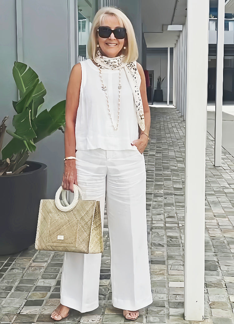 White sleeveless layered top with beaded trim and matching wide-leg pants