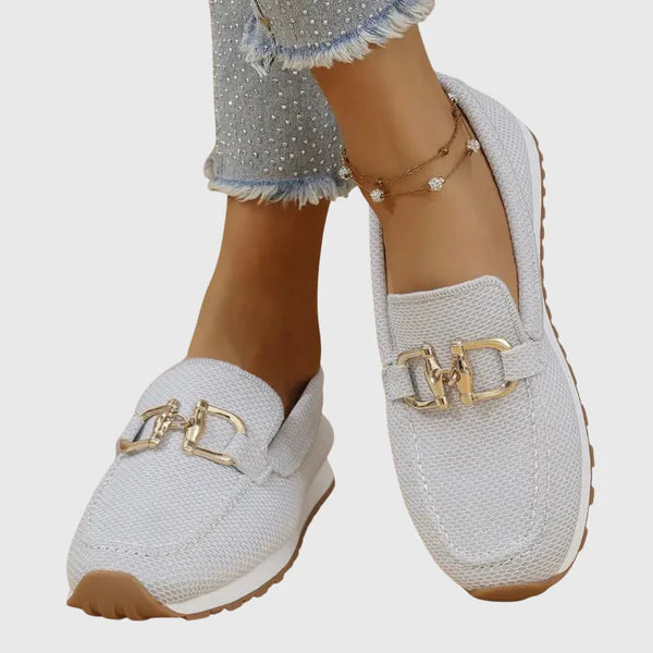 White women's loafers, slip-on style, gold buckle detail on textured upper
