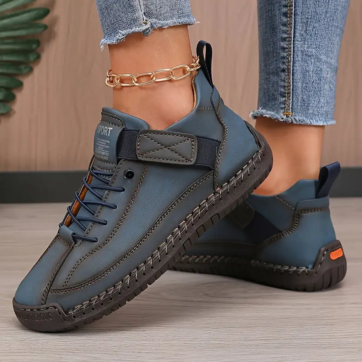 Blue lace-up sneakers with padded collar, stitching details, and grippy sole