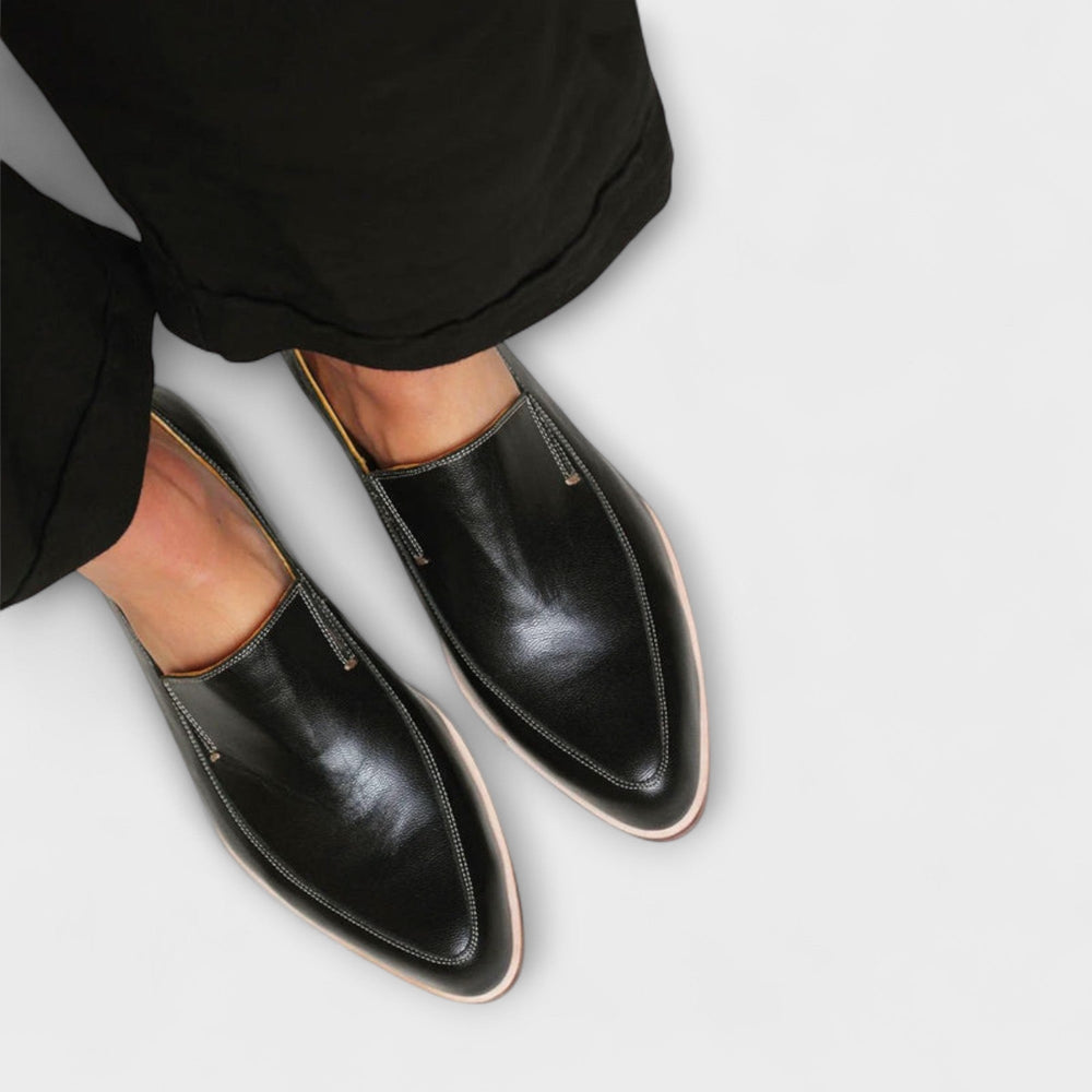 Black slip-on loafers with rounded toe and low profile heel; side stitching