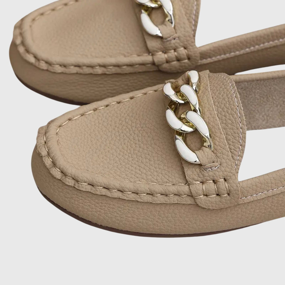 Beige women's chain loafer close-up of metal link ornament and stitched upper