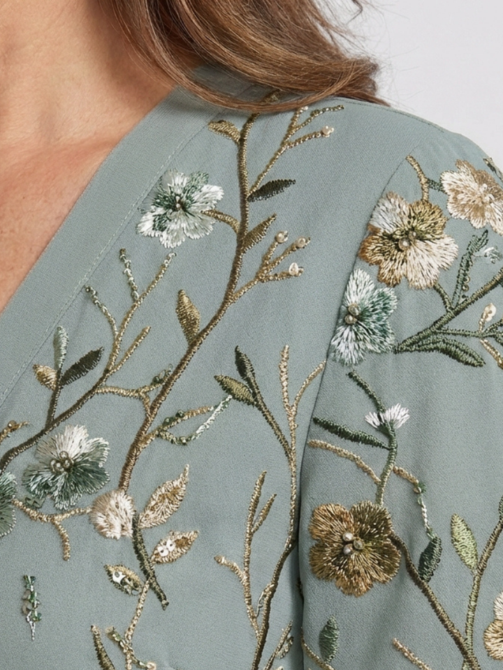 Green floral maxi dress close-up of embroidered blossoms on shoulder