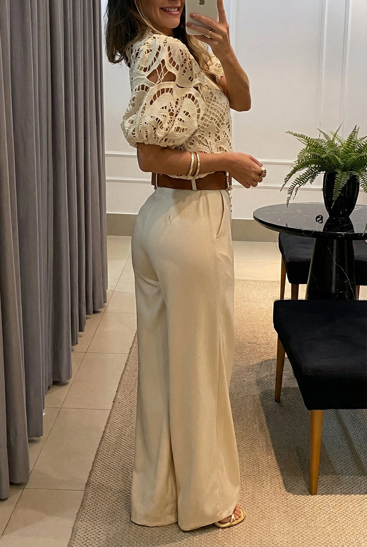 Cream lace blouse with puff sleeves and flowing high-rise wide-leg pants with belt
