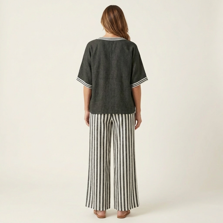Back view: dark gray V-neck varsity top with striped wide-leg pants in dark gray and white
