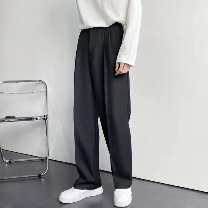 Black pleated wide-leg trousers, side view with relaxed straight leg opening