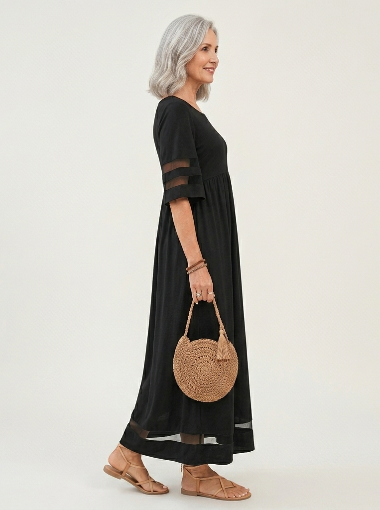 Black midi dress side view with gathered waist, sheer cutout sleeves, and mesh hem.
