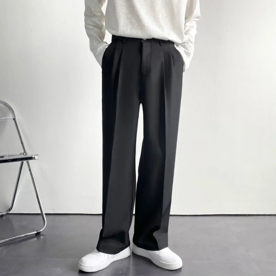Black pleated wide-leg trousers with tall waist and draped leg fall