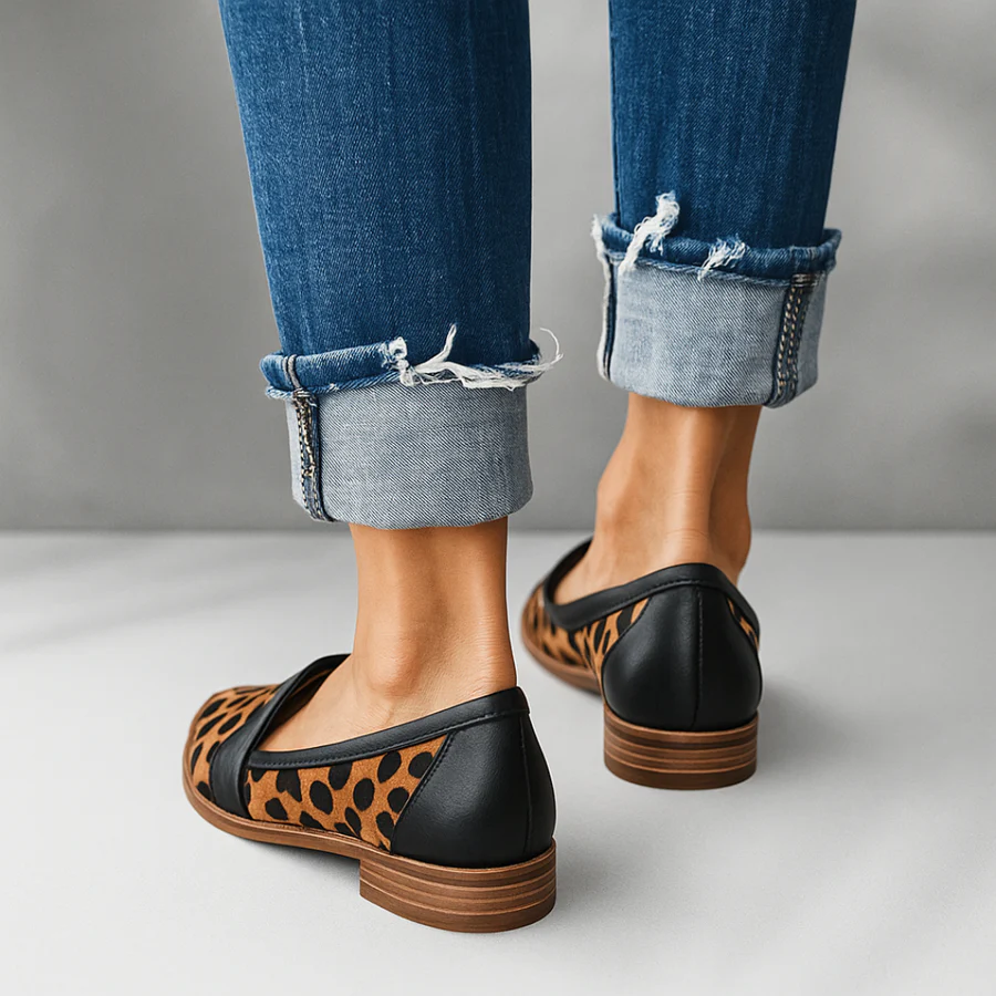 Black-backed leopard-print slip-on flat with wide black strap, low heel.