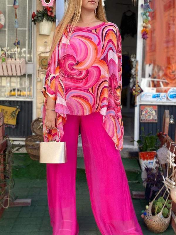 Pink two-piece set with swirl-print blouse and flowy magenta wide-leg pants