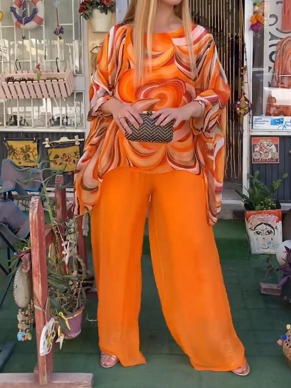 Orange two-piece set with swirled blouse and wide-leg pants in bright orange
