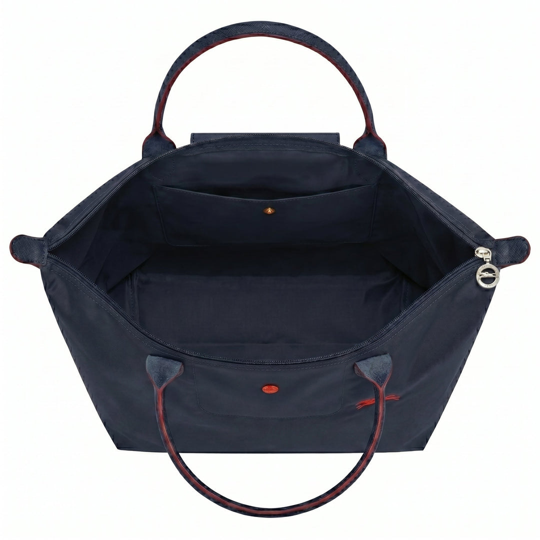 Open tote bag interior with structured lining and front flap pocket, red accents