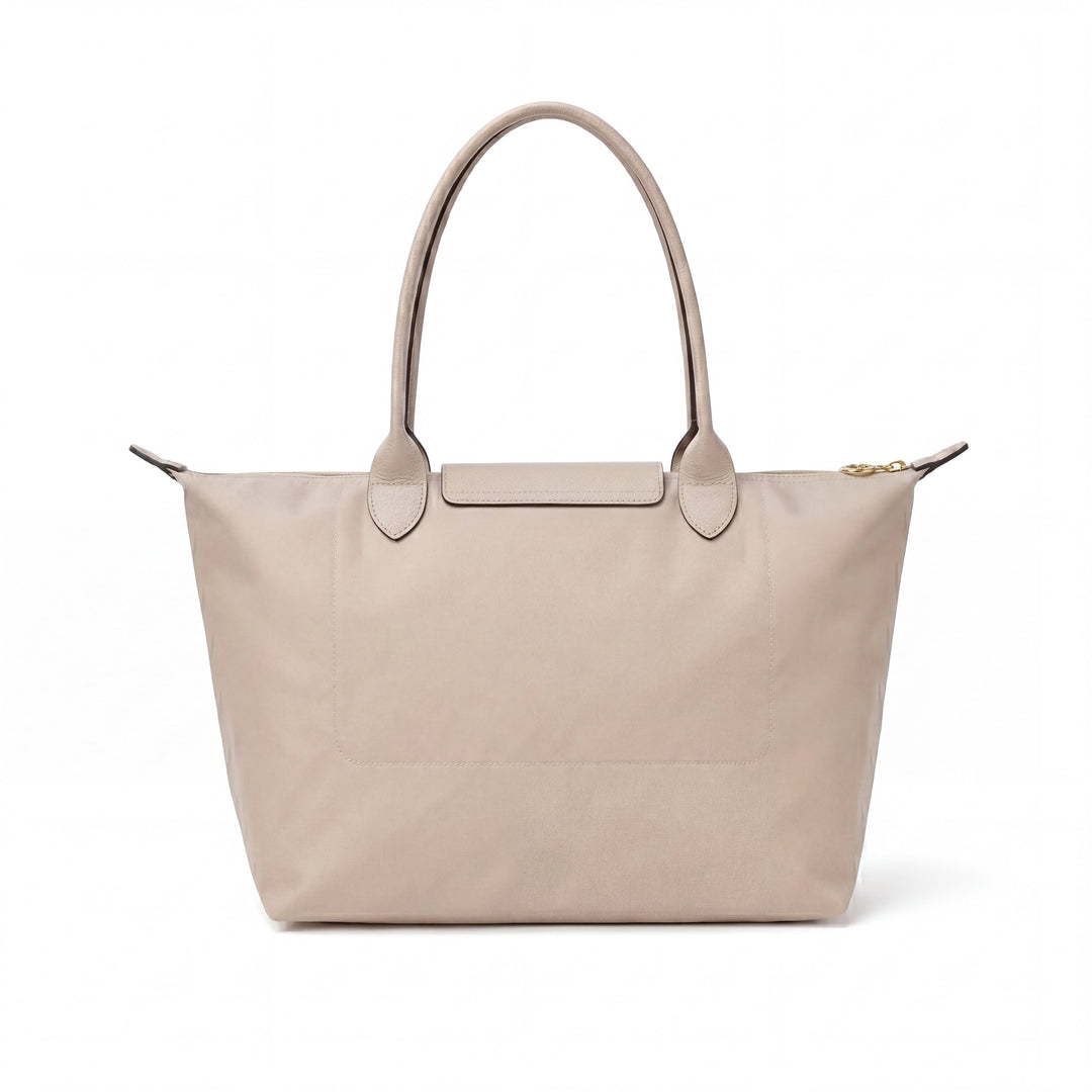 Light beige tote bag with short handles and flap closure, featuring subtle blue logo